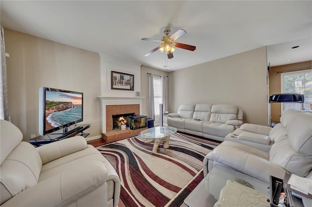 785 Hedgewick Trail Alpharetta, GA 30022 - Photo 7 of 32 a living room with furniture a fireplace and a flat screen tv