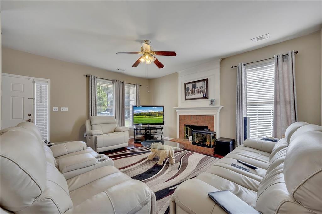 785 Hedgewick Trail Alpharetta, GA 30022 - Photo 9 of 32 a living room with furniture a fireplace and a window