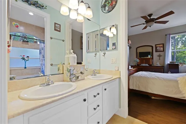 a spacious bedroom with a double vanity sink and a mirror