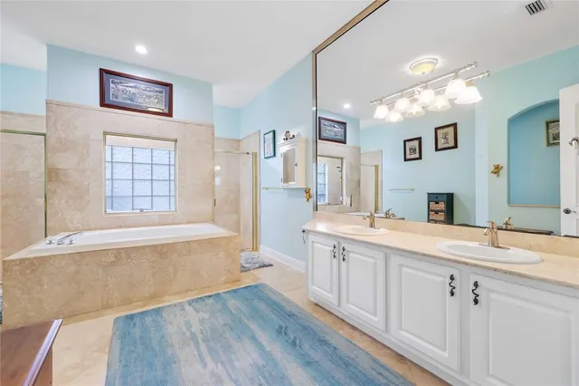 a spacious bathroom with a sink a large mirror and a bathtub