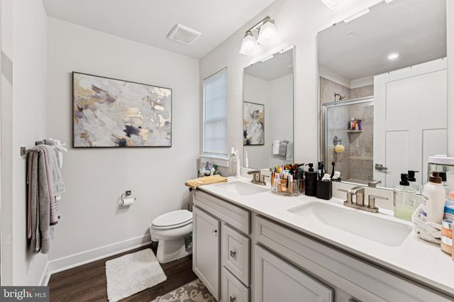 a bathroom with a double vanity sink toilet and a mirror