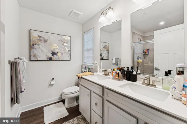 a bathroom with a double vanity sink toilet and a mirror
