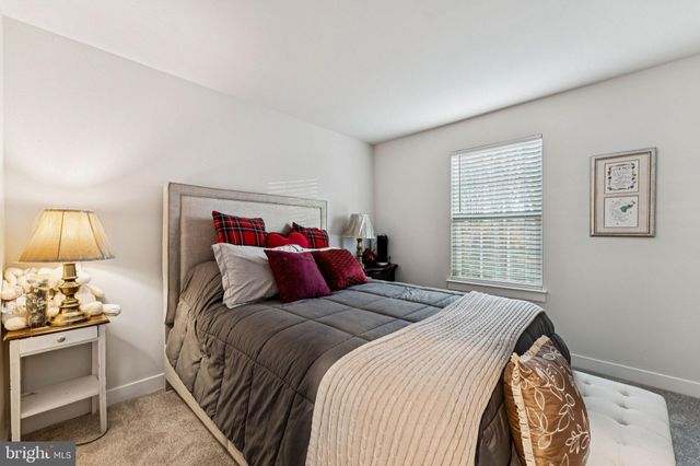 a bedroom with a bed and a lamp on the dresser