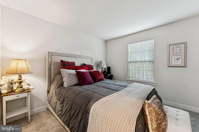 a bedroom with a bed and a lamp on the dresser
