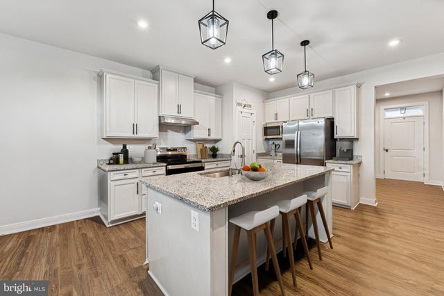 a kitchen with a center island appliances and cabinets