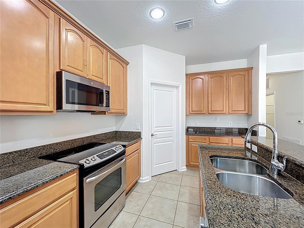 12930 Vennetta Way Windermere, FL 34786 - Photo 9 of 38 a kitchen with granite countertop a sink cabinets and stainless steel appliances