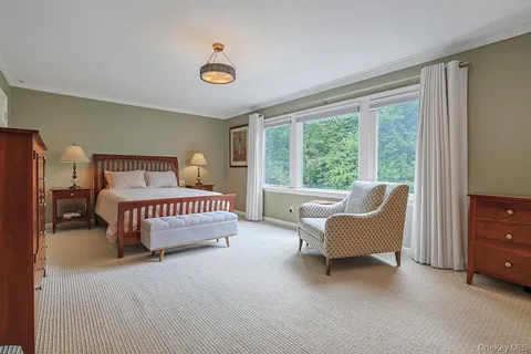 a bedroom with a bed and a large window