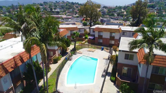 an aerial view of a house with a swimming pool and outdoor seating