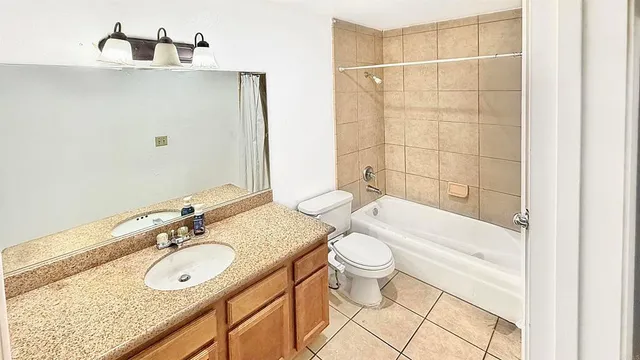 a bathroom with a granite countertop sink a toilet and bathtub