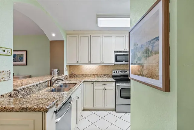 a kitchen with stainless steel appliances granite countertop a sink stove and cabinets