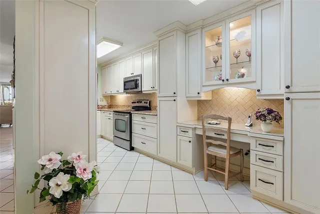 a kitchen with stainless steel appliances a stove a refrigerator and white cabinets