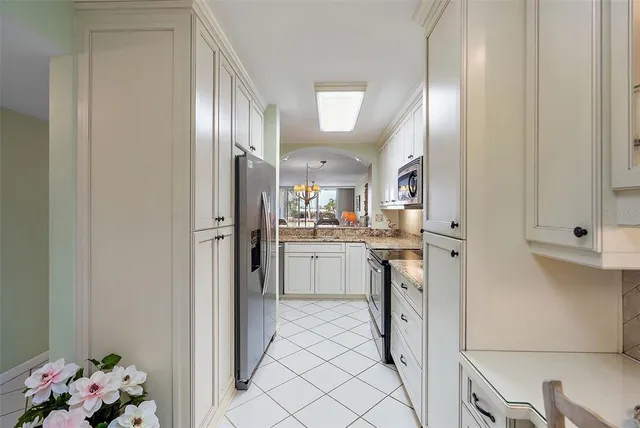 a kitchen with white cabinets and refrigerator