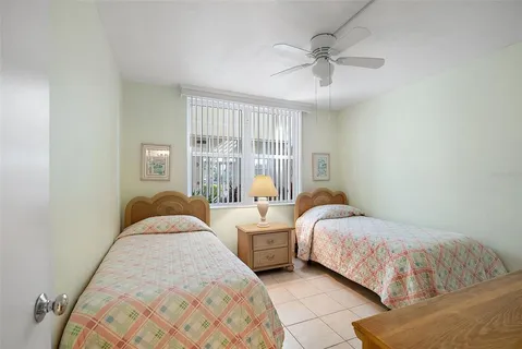 a bedroom with two beds and ceiling fan
