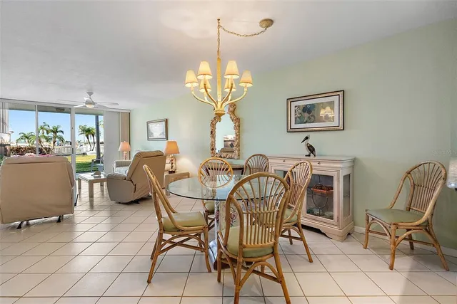 a view of a dining room and livingroom with furniture a chandelier and wooden floor