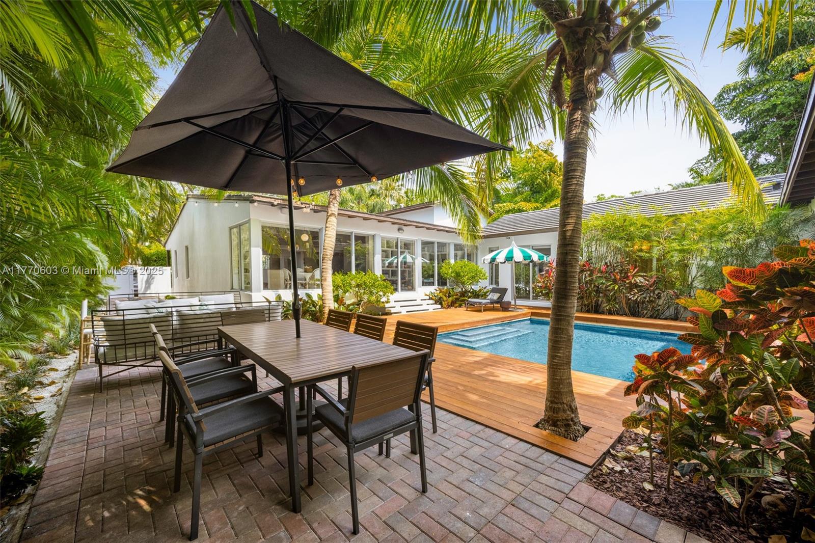 4140 Battersea Road Coconut Grove, FL 33133 - Photo 32 of 37 a view of a patio with table and chairs under an umbrella