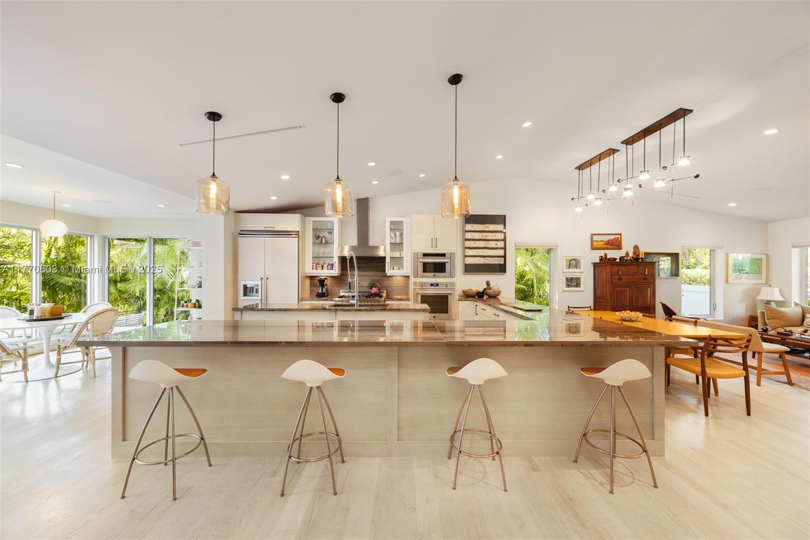 4140 Battersea Road Coconut Grove, FL 33133 - Photo 4 of 37 a kitchen with stainless steel appliances kitchen island granite countertop a table and chairs in it