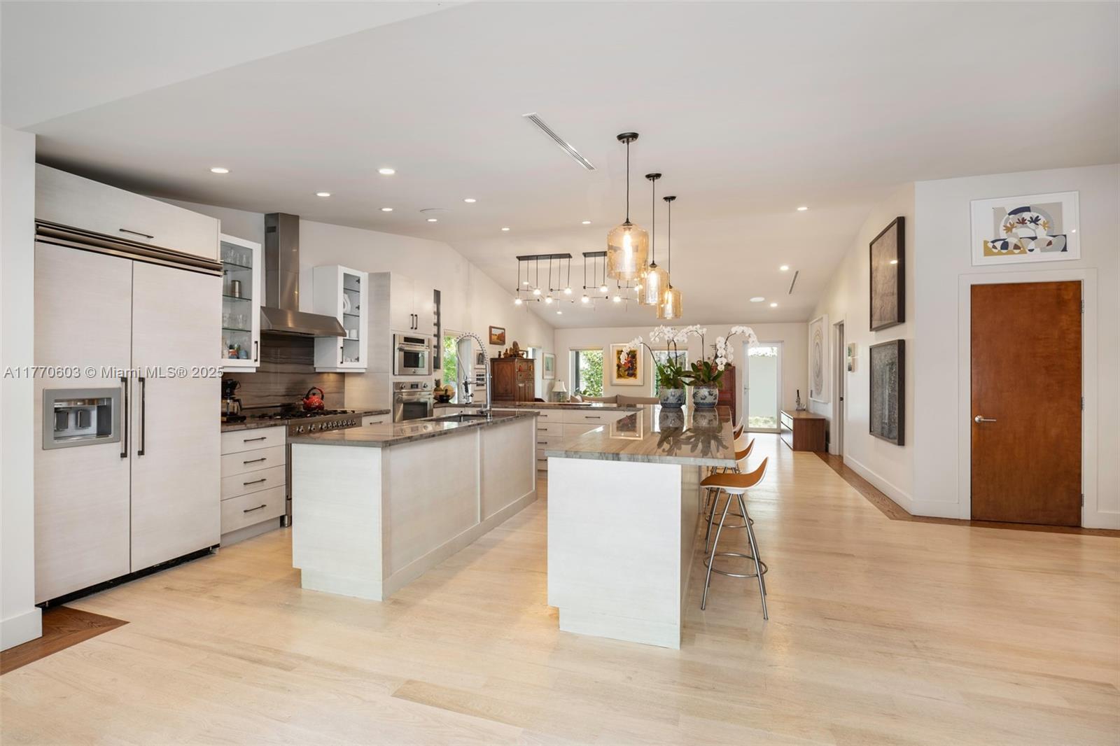 4140 Battersea Road Coconut Grove, FL 33133 - Photo 6 of 37 a kitchen with stainless steel appliances kitchen island granite countertop a refrigerator a stove top oven a sink a dining table and chairs with wooden floor