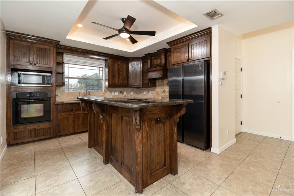 8907 North 36th Lane McAllen, TX 78504 - Photo 6 of 16 a kitchen with kitchen island granite countertop a stove sink and cabinets