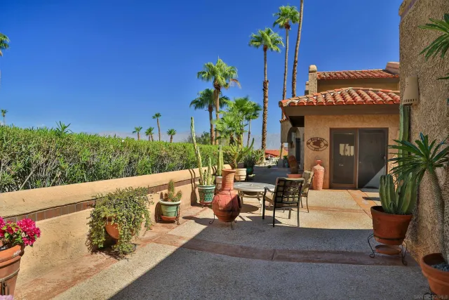 a view of a patio with couches table and chairs and potted plants