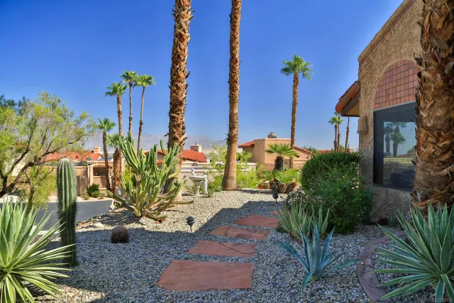 a view of a palm trees front of house