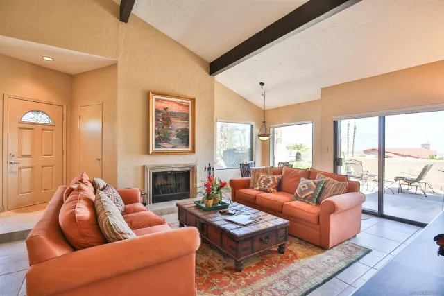 a living room with furniture fireplace and a large window