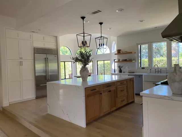 a kitchen with kitchen island a counter top space a sink appliances and cabinets