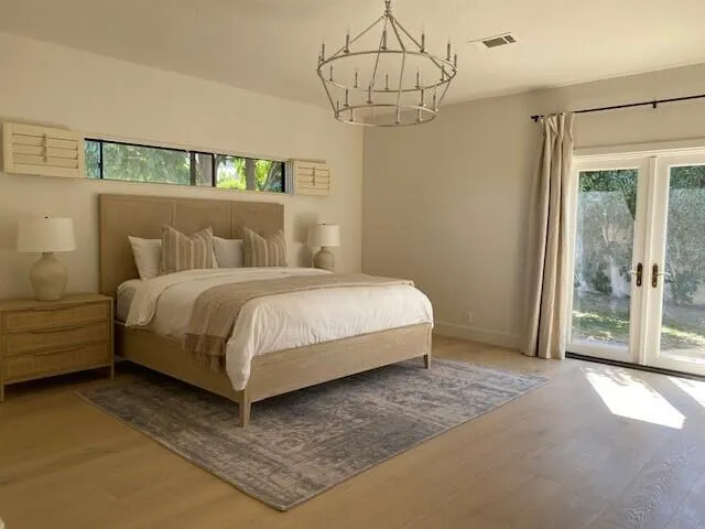 a bedroom with a large bed and a chandelier