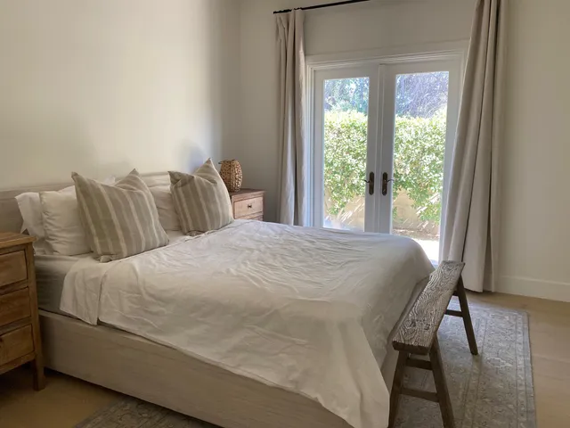 a bed sitting in a bedroom next to a window