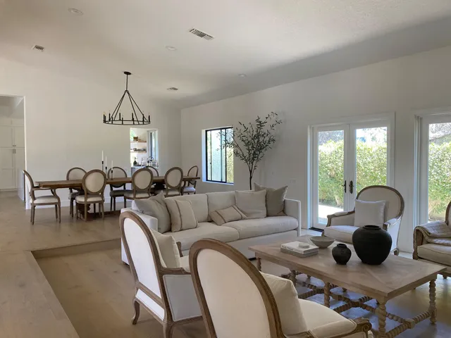 a living room with furniture a couch and large windows