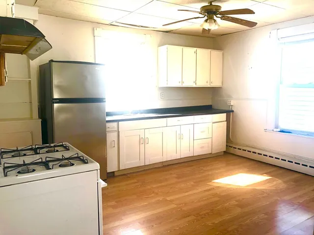 a kitchen with a stove a refrigerator and a microwave