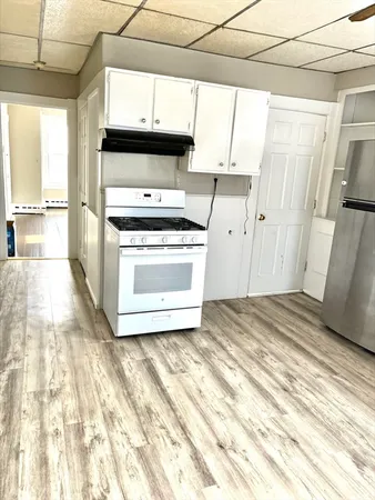a kitchen with a stove a sink and a window