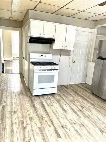 a kitchen with a stove a sink and a window