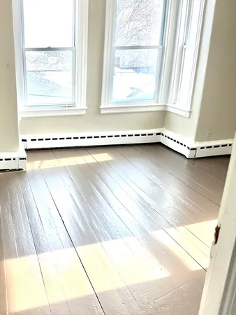 a view of a room with wooden floor and a window
