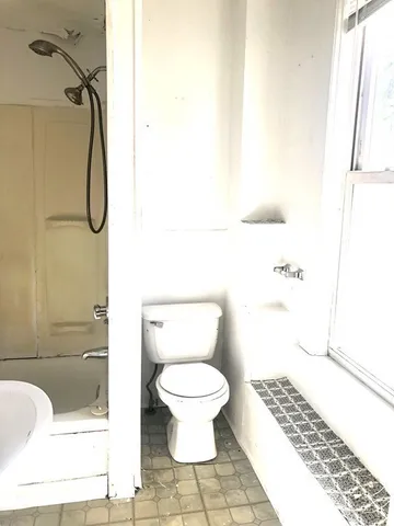 a bathroom with a toilet and a shower