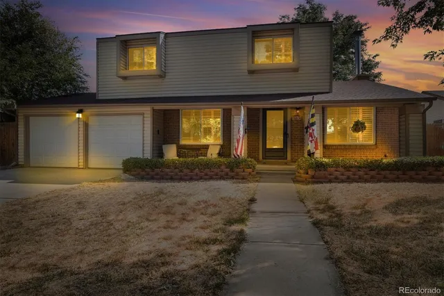 a view of a house with brick walls and a yard