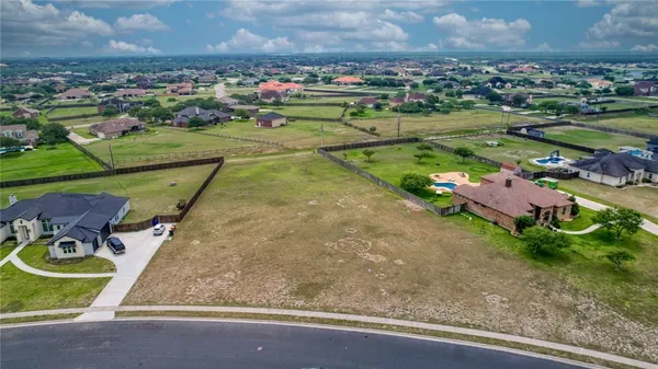 an aerial view of a house with a yard and lake