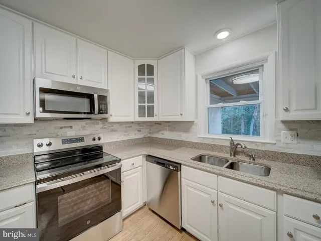 a kitchen with appliances a sink and cabinets