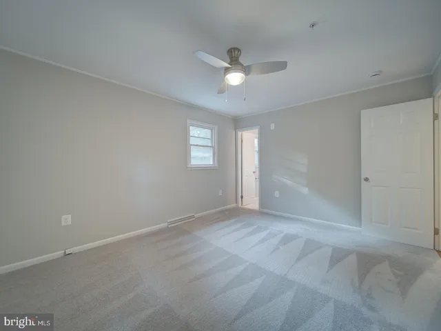 an empty room with fan and entrance