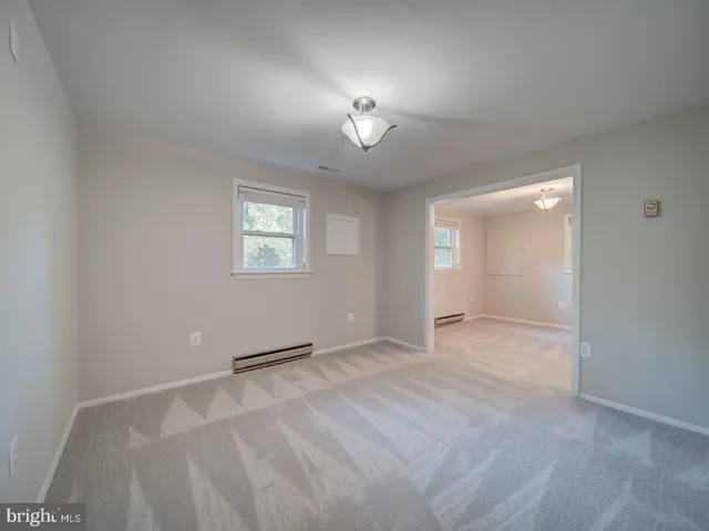 a view of an empty room with closet and a window