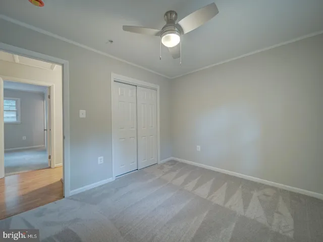 a view of an empty room with a chandelier fan