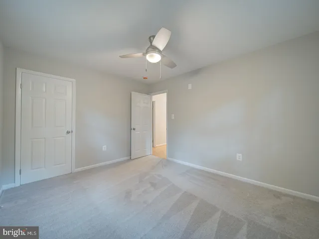 a view of an empty room and chandelier fan