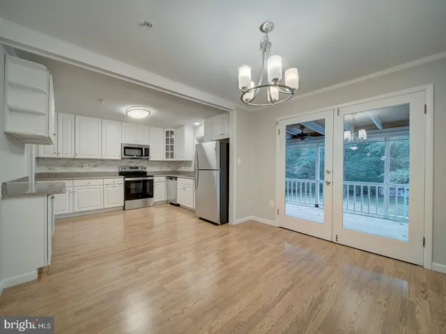 a view of a kitchen with granite countertop stainless steel appliances and a chandelier