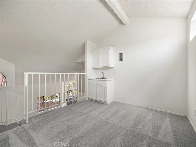 a view of an empty room with closet and a window
