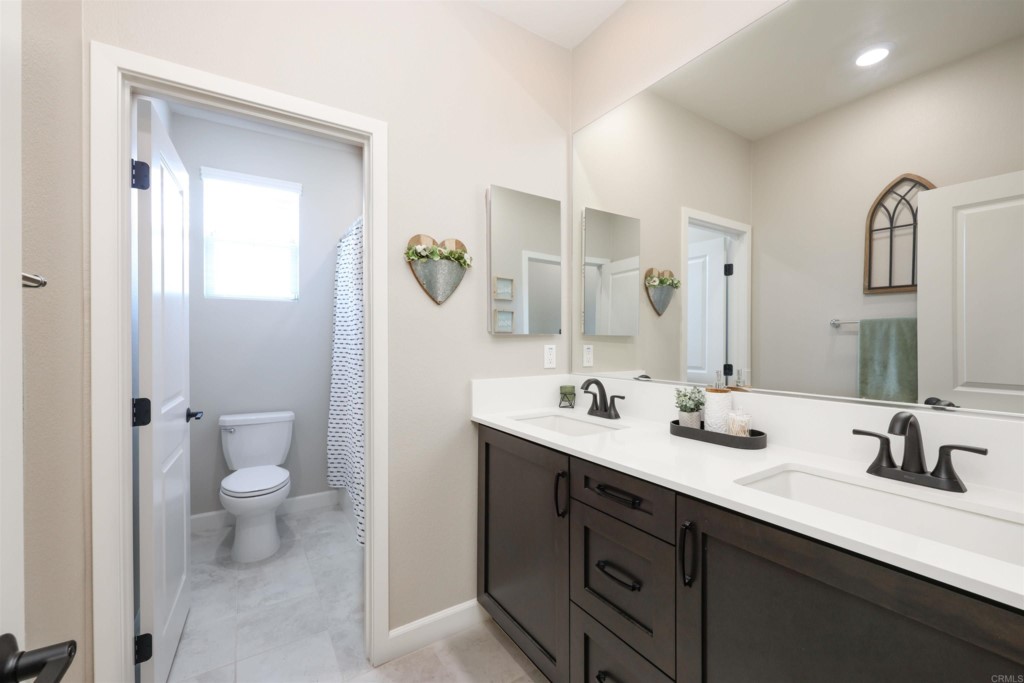 1112 Delpy View Point Vista, CA 92084 - Photo 34 of 62 a bathroom with a sink a toilet and a large mirror