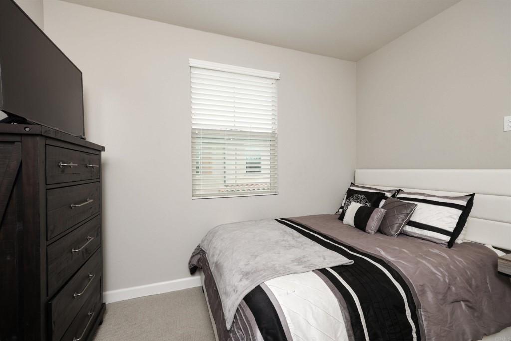 1112 Delpy View Point Vista, CA 92084 - Photo 37 of 62 a bedroom with a bed and a flat tv screen on a dresser