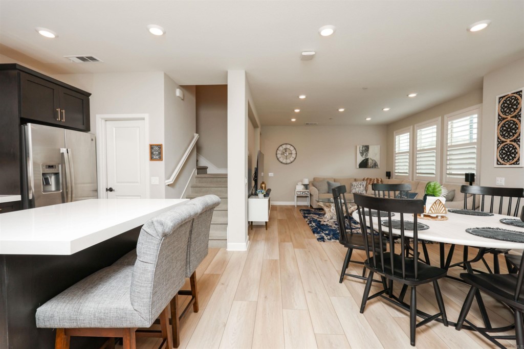 1112 Delpy View Point Vista, CA 92084 - Photo 38 of 62 a kitchen with stainless steel appliances kitchen island granite countertop a dining table chairs and a refrigerator