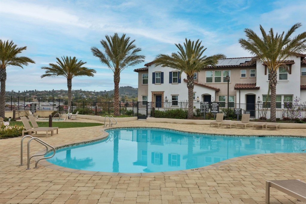 1112 Delpy View Point Vista, CA 92084 - Photo 52 of 62 a view of a swimming pool with a chair and palm trees