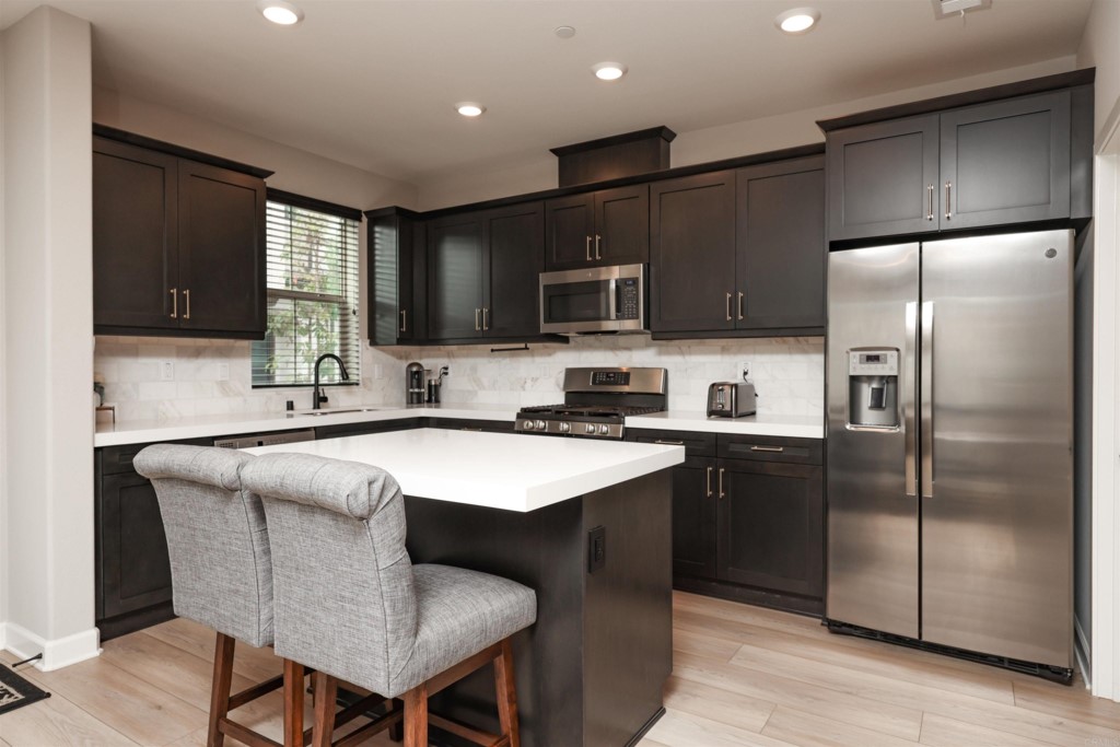 1112 Delpy View Point Vista, CA 92084 - Photo 54 of 62 a kitchen with stainless steel appliances granite countertop a refrigerator a sink a stove a microwave and wooden cabinets