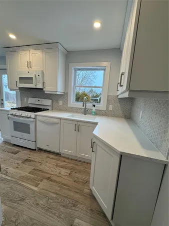 a large kitchen with stainless steel appliances granite countertop a stove a sink and a refrigerator