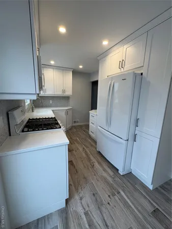 a view of a kitchen with wooden floor and electronic appliances